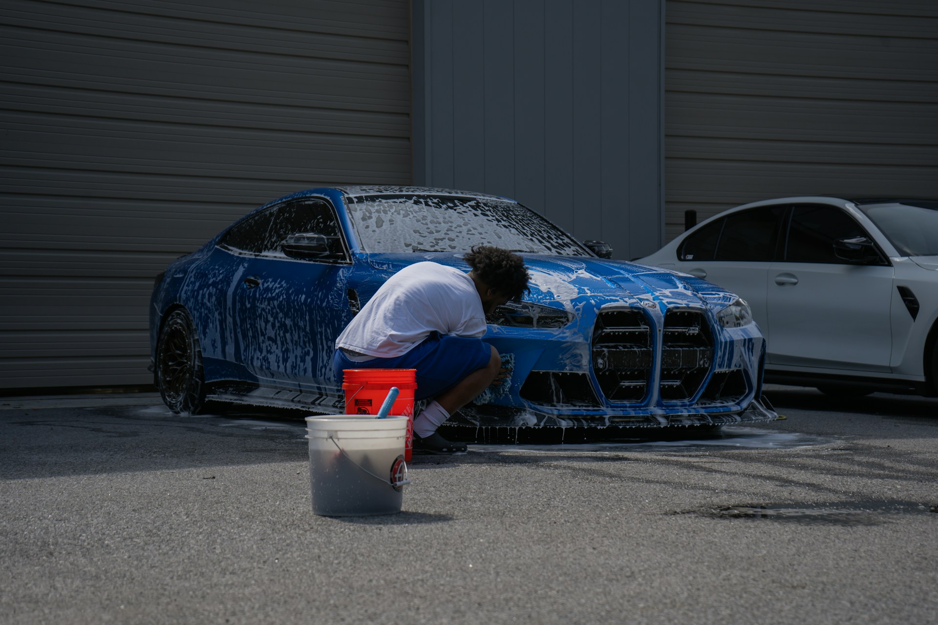 a detailer washing a blue bmw